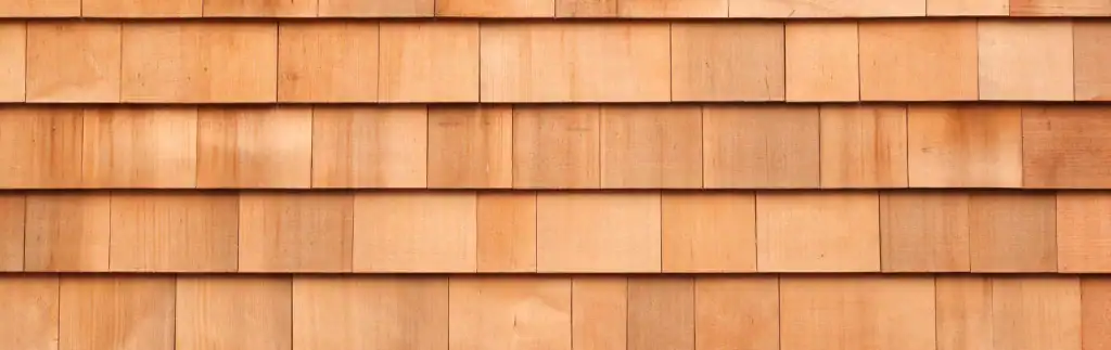 Cedar shake siding repair showing new and old shingles on a house exterior.