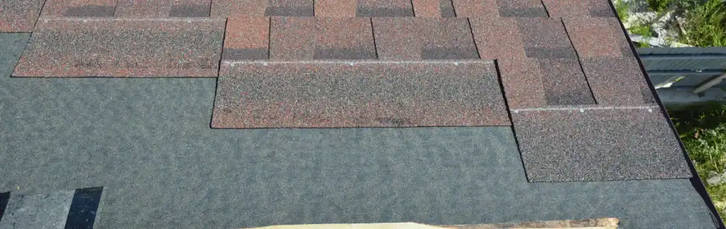 Shingles repair on a residential roof showing missing and damaged shingles.