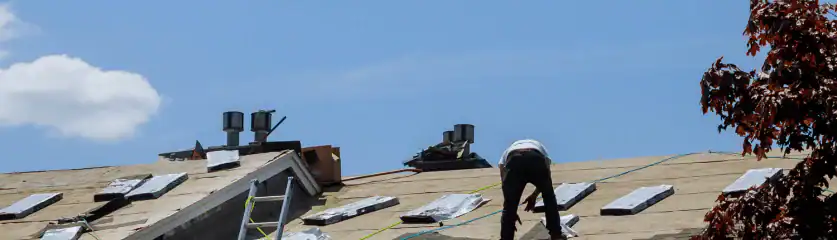 Emergency roof repair work being performed on a residential home after storm damage.