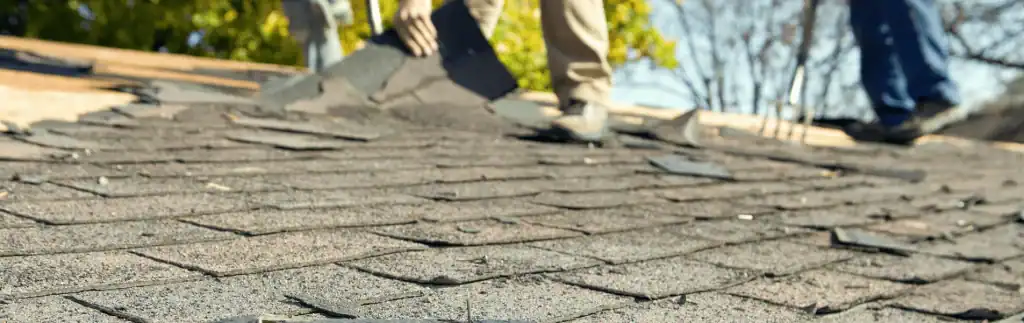 Emergency roof repair work being performed on a residential home after storm damage.
