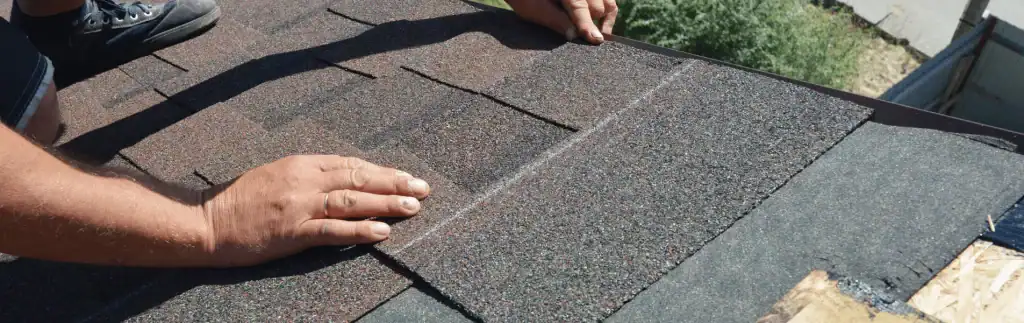 Installing new asphalt shingles on a residential roof for replacement and durability.