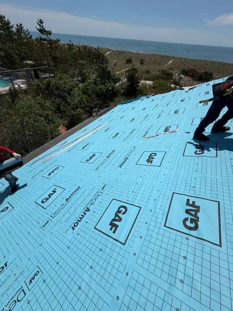 Roof under construction with GAF roofing underlayment near the coast.