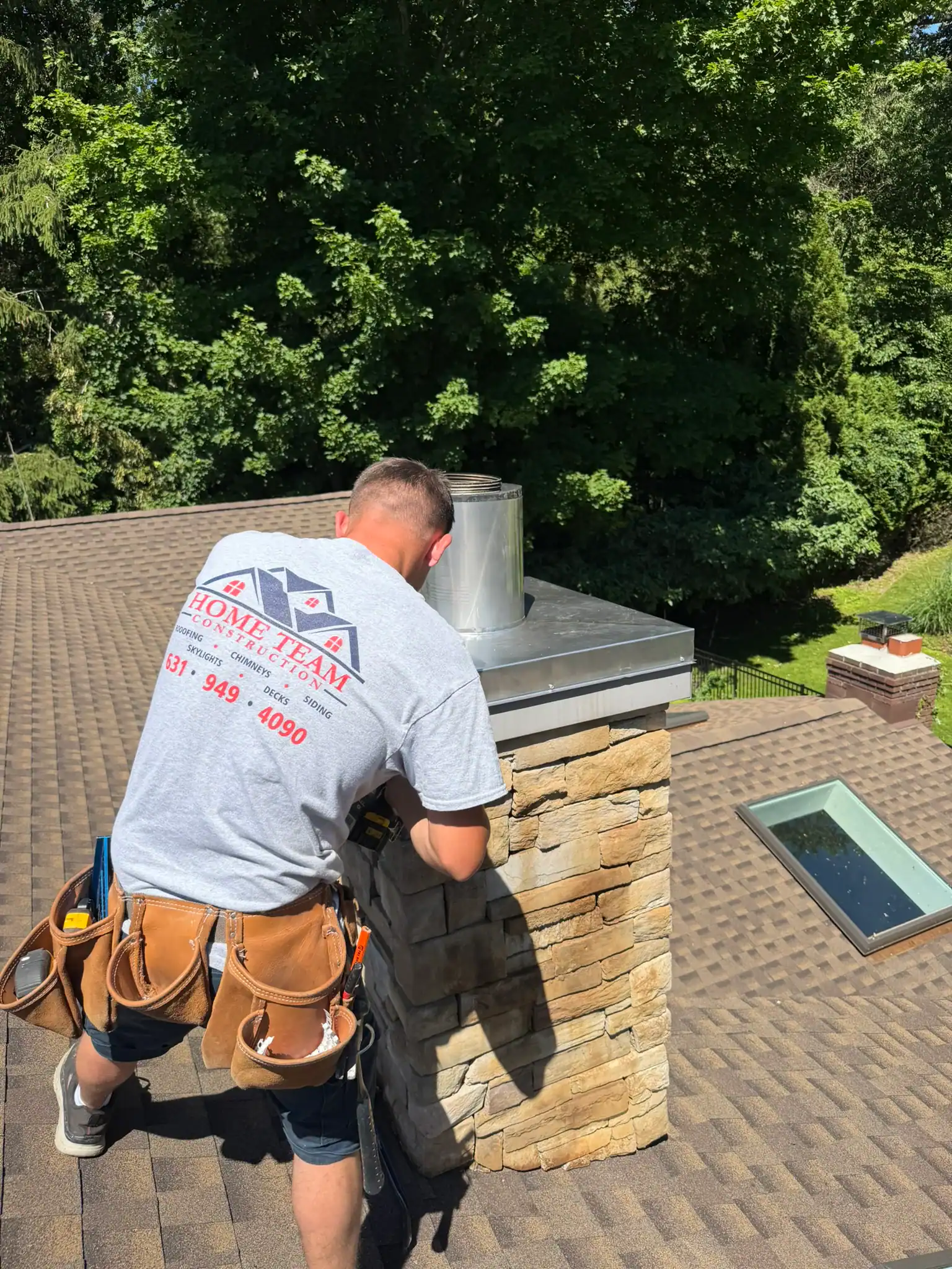 Home Team Construction technician inspecting chimney on roof.