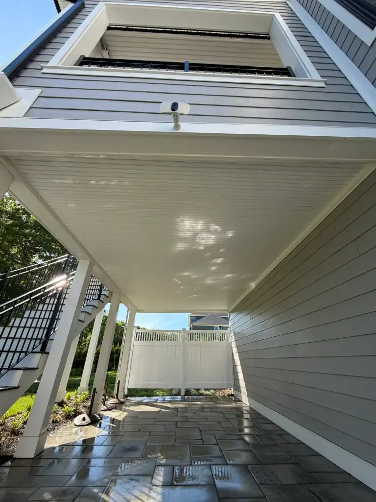 Newly constructed house exterior with covered patio and modern siding.